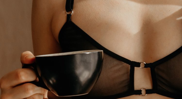 woman in black brassiere holding black ceramic bowl