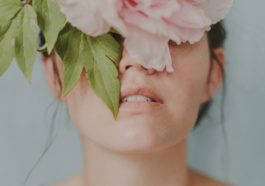 woman in white tank top with white and pink rose on her ear